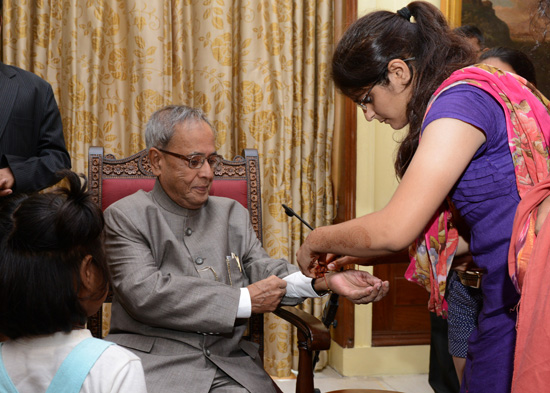 Children from Vatsalya Gram, Param Shaktipeeth Vrindavan tied a Rakhi on the wrist of the President of India, Shri Pranab Mukherjee at Rashtrapati Bhavan in New Delhi on August 24, 2013 when they called-on the President.