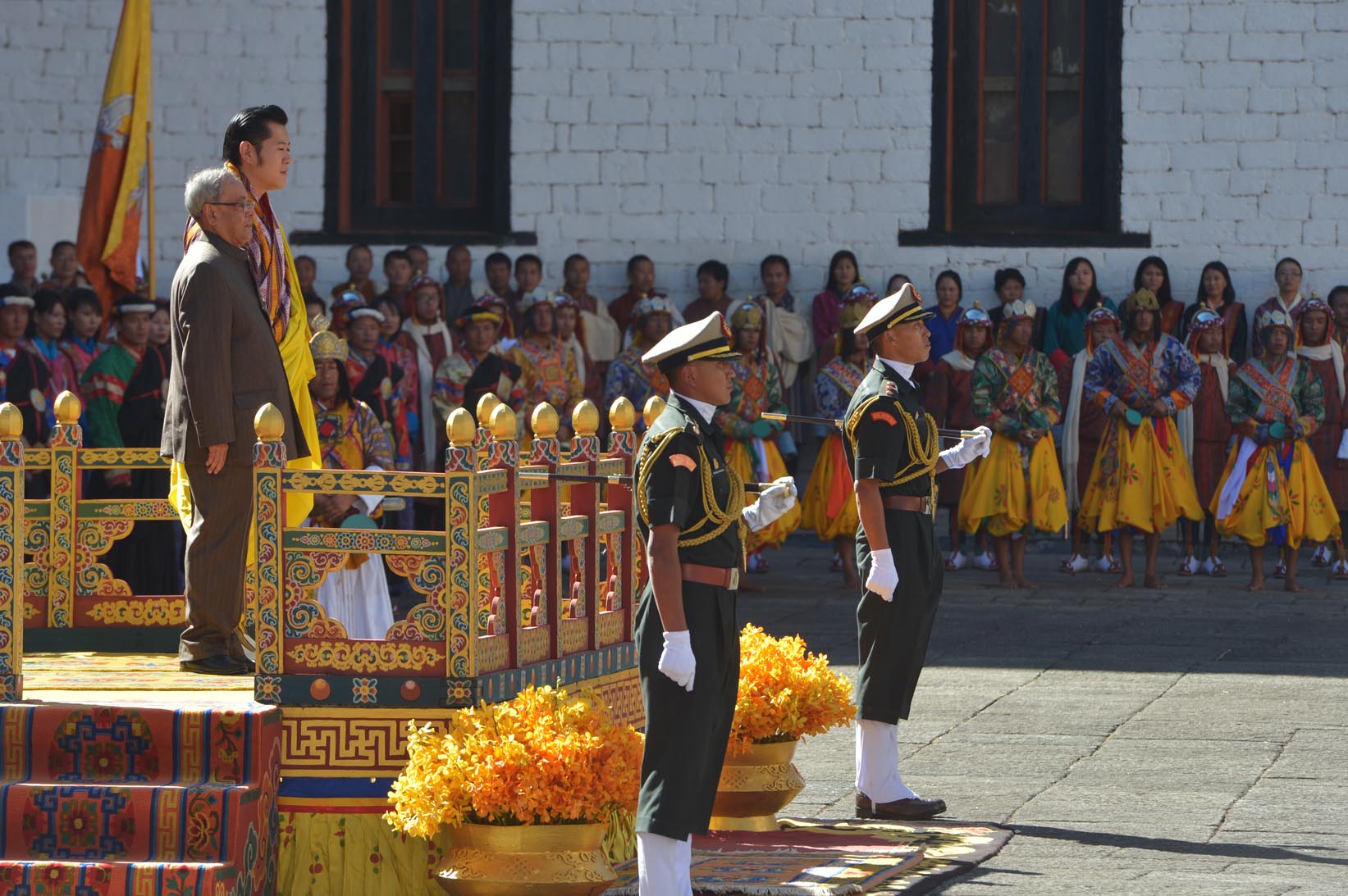 भारत के राष्ट्रपति, श्री प्रणब मुखर्जी 7 नवंबर, 2014 को, ताशीछोडोंग, थिंपू भूटान में अपने समारोहिक स्वागत में सम्मान गारद को स्वीकार करते हुए। चित्र में भूटान नरेश, महामहिम जिग्मी खेसर नामग्येल वांग्चुक भी दिखाई दे रहे हैं। 